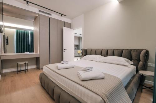 a bedroom with a large bed with two towels on it at DAED Luxury Residence in Sarandë
