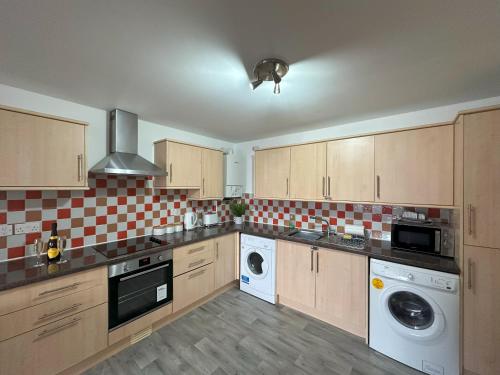 a large kitchen with a washer and dryer in it at Curwen Apartment - 2 Bedrooms - Sleeps 6 in Workington