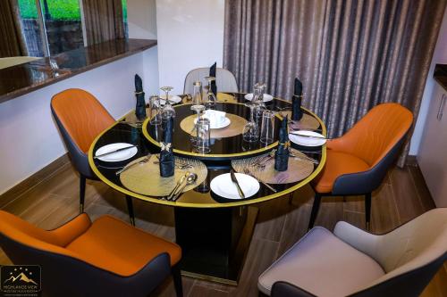 uma mesa de jantar com cadeiras laranja à volta em Highlands View Boutique Villas & Resort, Nyeri em Nyeri