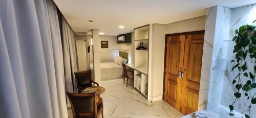 a hallway with a bathroom with a tub and a door at Antonio's Hotel e Spa - Airport in Brasilia