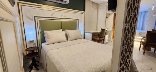 a bedroom with a bed and a desk and a chair at Antonio's Hotel e Spa - Airport in Brasilia
