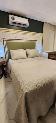 a bedroom with a large bed with a air conditioner on the wall at Antonio's Hotel e Spa - Airport in Brasilia