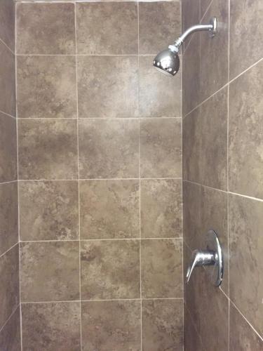 a shower with a glass door with a shower head at Roxy Hotel in Los Angeles
