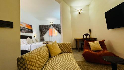 a living room with a couch and a bed at Hotel Dior in Saint-Louis