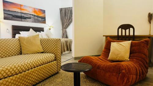 a living room with a couch and a chair at Hotel Dior in Saint-Louis