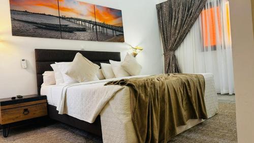 a bedroom with a bed and a painting on the wall at Hotel Dior in Saint-Louis