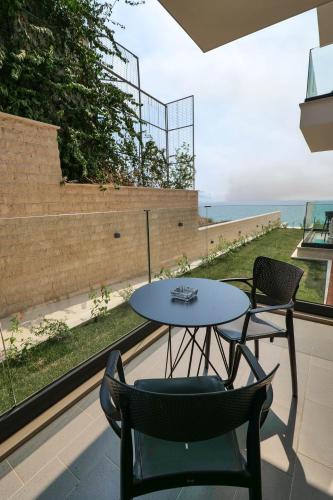 a table and chairs on a balcony with a view of the ocean at DAED Luxury Residence in Sarandë