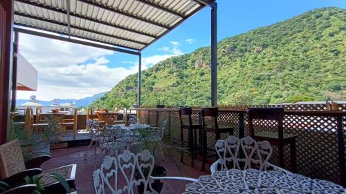 a balcony with tables and chairs and a mountain at Royal Palace Hostal in Panajachel