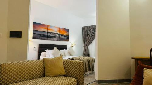 a hotel room with a bed and a couch at Hotel Dior in Saint-Louis
