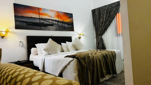 a bedroom with two beds and a painting on the wall at Hotel Dior in Saint-Louis