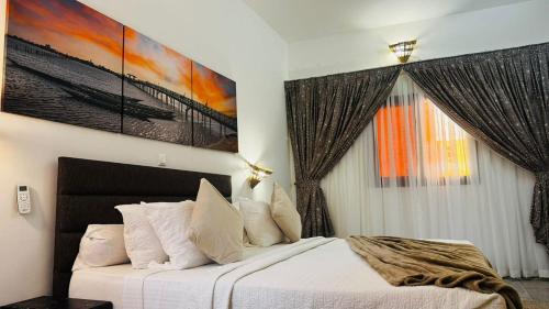 a bedroom with a bed and a painting on the wall at Hotel Dior in Saint-Louis