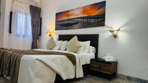 a bedroom with a bed and a painting on the wall at Hotel Dior in Saint-Louis
