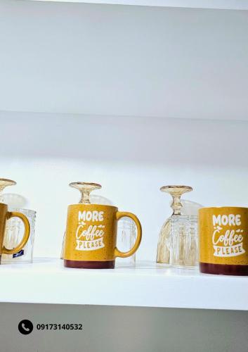 a shelf with two more coffee mugs on it at Gab's Place Sudio Unit, Marina Spatial in Dumaguete