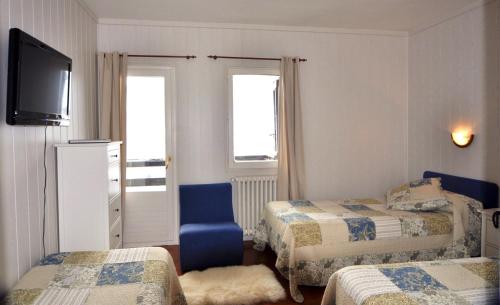 a hotel room with two beds and a television at Hotel Tirol in Formigal