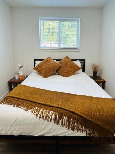 a bed with two brown pillows and a window at WesterHaven- 2 bd Garden Level in Nampa