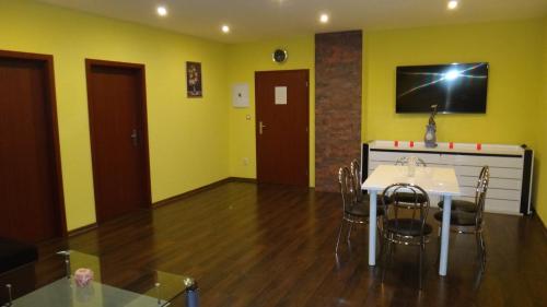 a room with a table and chairs and a tv on the wall at Penzión Melódia in Kanianka