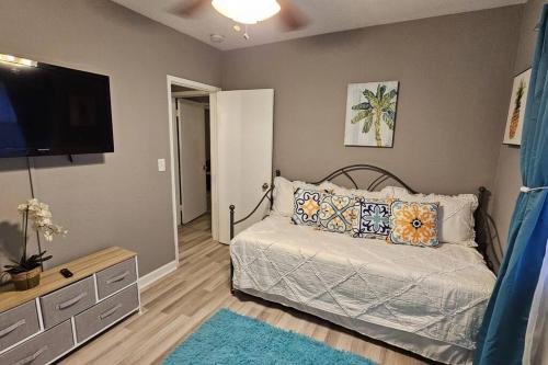 a bedroom with a bed and a flat screen tv at Wynwood Miami Family Oasis in Miami