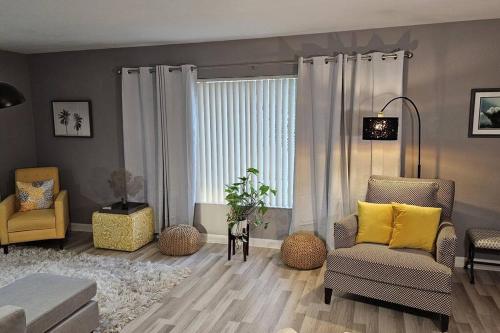 a living room with two chairs and a window at Wynwood Miami Family Oasis in Miami