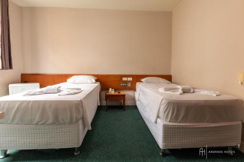 two beds in a hotel room with at Rede Andrade San Martin in Curitiba