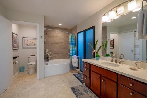 a bathroom with a tub and a toilet and a sink at Mauna Kai 5A in Princeville