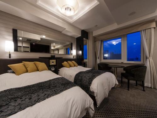 a hotel room with two beds and a window at APA Hotel Higashi Shinjuku Kabukicho Higashi in Tokyo