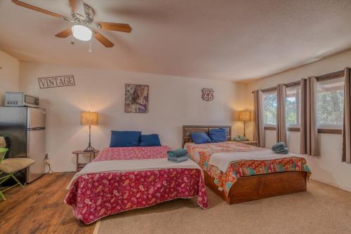 a bedroom with two beds and a ceiling fan at Enchanted Hideaway Cabins and Cottages in Ruidoso