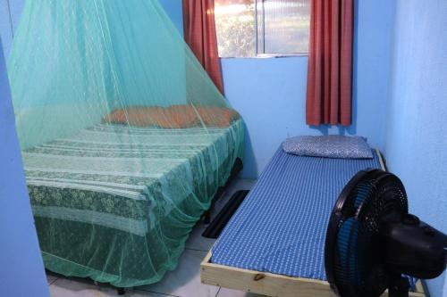 Un dormitorio con una cama y un banco en una habitación. en Casinha do Pedro - I love Boipeba, en Isla de Boipeba