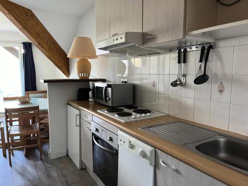 une cuisine avec un évier et une cuisinière four supérieur dans l'établissement Résidence Balcons Du Soleil 1 - T2/6pers BALCONS DU SOLEIL 71- Peyresourde MAE-9404, à Germ