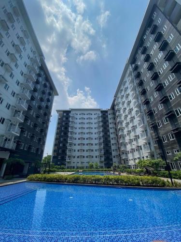 two large apartment buildings with a swimming pool at MG Place -2 BR condo unit at SMDC Charm Residences, Cainta, Rizal, 1900 in Cainta