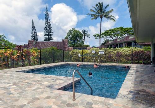 a swimming pool with two people in the water at Puamana 9C in Princeville