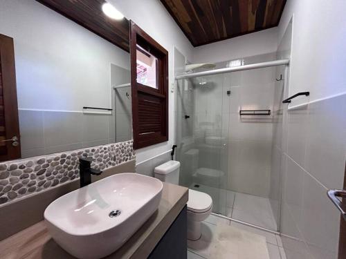 a white bathroom with a sink and a shower at Oka Káa - Bosque da Praia Pipa Flat 33 in Pipa