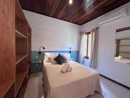 a bedroom with a bed with white sheets and a window at Oka Káa - Bosque da Praia Pipa Flat 33 in Pipa