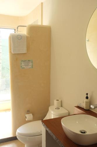a bathroom with a white toilet and a sink at Hotel Circulo Bacalar in Bacalar