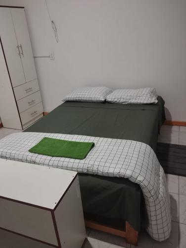 a model of a bed with a green pillow on it at Alojamiento Parque 38 in Talara