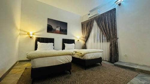 a hotel room with two beds and a window at Hotel Dior in Saint-Louis
