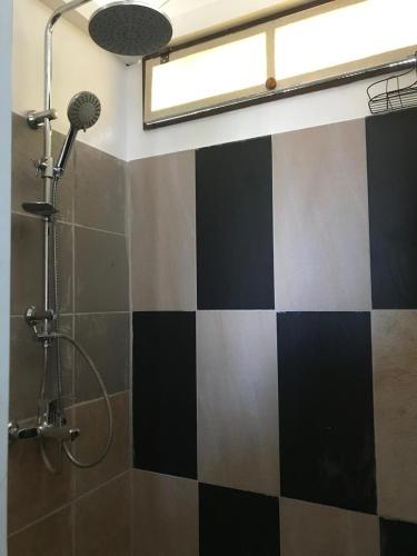a bathroom with a black and white checkered wall at Palm lodge Faaa in Faaa