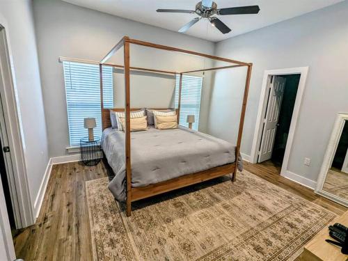 a bedroom with a canopy bed and a fan at Tegarden Cottage at Gulfport Beach in Gulfport