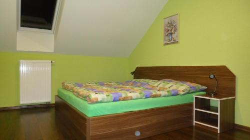 a bedroom with a bed in a room with green walls at Penzión Melódia in Kanianka