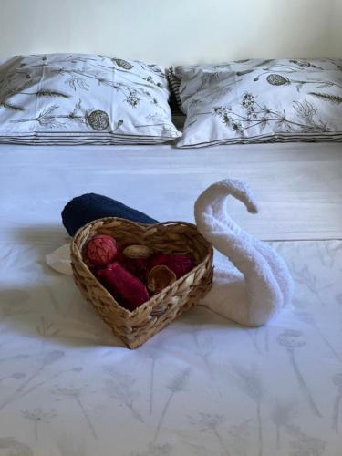 a basket of yarn and a swan on a bed at Le Ketmie nature et découverte in Fond-Saint-Denis