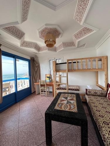 a living room with bunk beds and a table at Surfstay-Taghazout in Taghazout