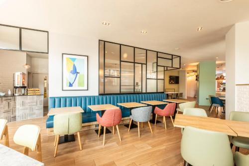 a dining room with tables and chairs in a restaurant at Holiday Inn London Sutton by IHG in Sutton