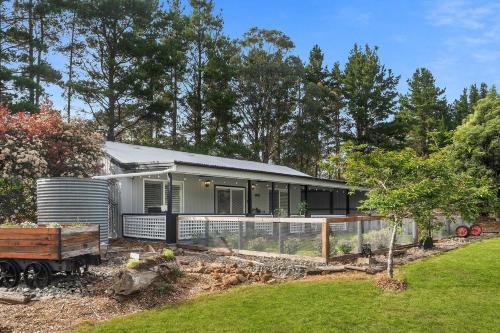 a house with a fence and a yard at The Cottage, Colo Vale, Southern Highlands in Colo Vale