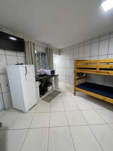 a kitchen with a refrigerator and a table in it at BERTIOGA suítes na praia centro in Bertioga