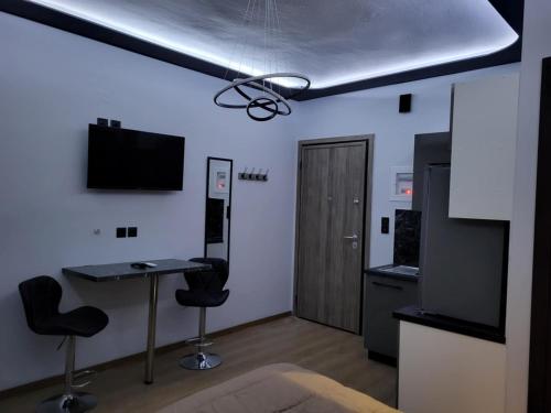 a room with a desk and two chairs and a television at LUX&EAZY central modern studio in Ioannina