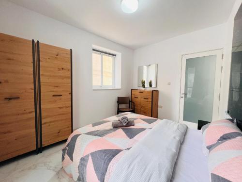 a bedroom with a bed and a dresser at Beachfront Room DR in St Paul's Bay