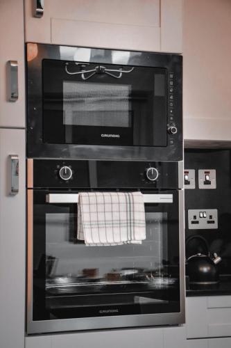 a black oven with a towel hanging from it at Beachfront Room DR in St Paul's Bay