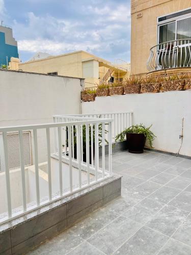 a balcony with a white railing on a building at Beachfront Room DR in St Paul's Bay