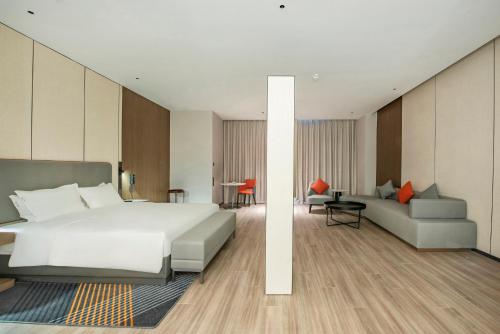 a bedroom with a large white bed and a couch at Holiday Inn Express Yinchuan Lanxi Valley Plaza by IHG in Yinchuan
