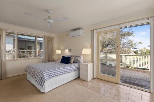 a bedroom with a bed and a balcony at Seaview Splendour in Point Lonsdale