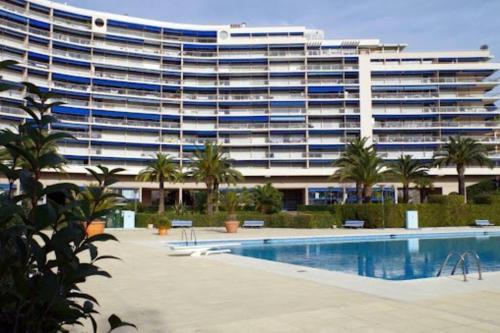 un grand bâtiment avec une piscine en face d'un bâtiment dans l'établissement Studio Cannes Marina - port Mandelieu, à Mandelieu-la-Napoule